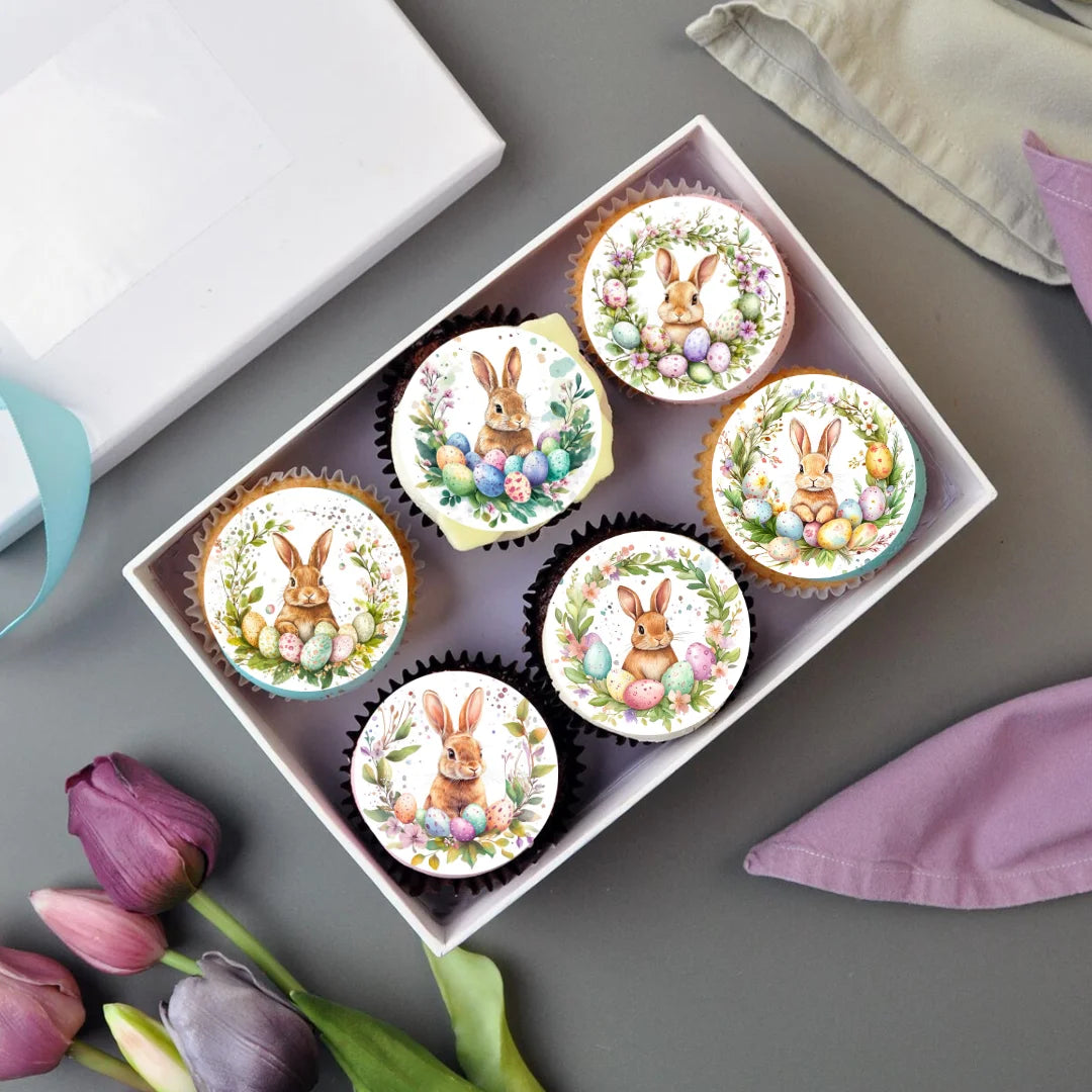 Easter bunny wreath design edible cupcake toppers, placed on white frosted cupcakes in a cake box
