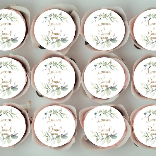 green foliage Personalised Wedding Cupcake Toppers with personalised name and date in gold lettering shown on cupcakes in a box