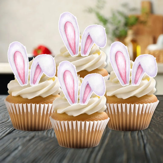 Edible wafer Easter bunny ears on white frosted cupcakes on a kitchen counter