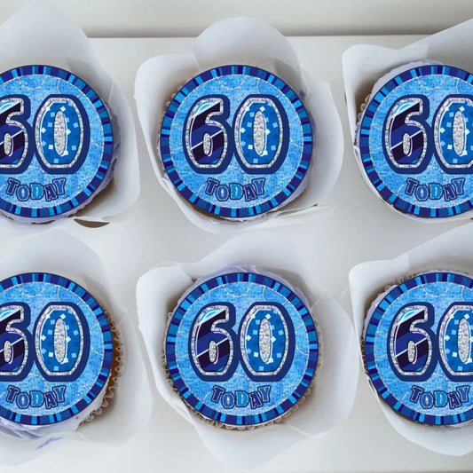 60th Birthday Blue Edible Cupcake Toppers with foil balloon style design on top of frosted cupcakes