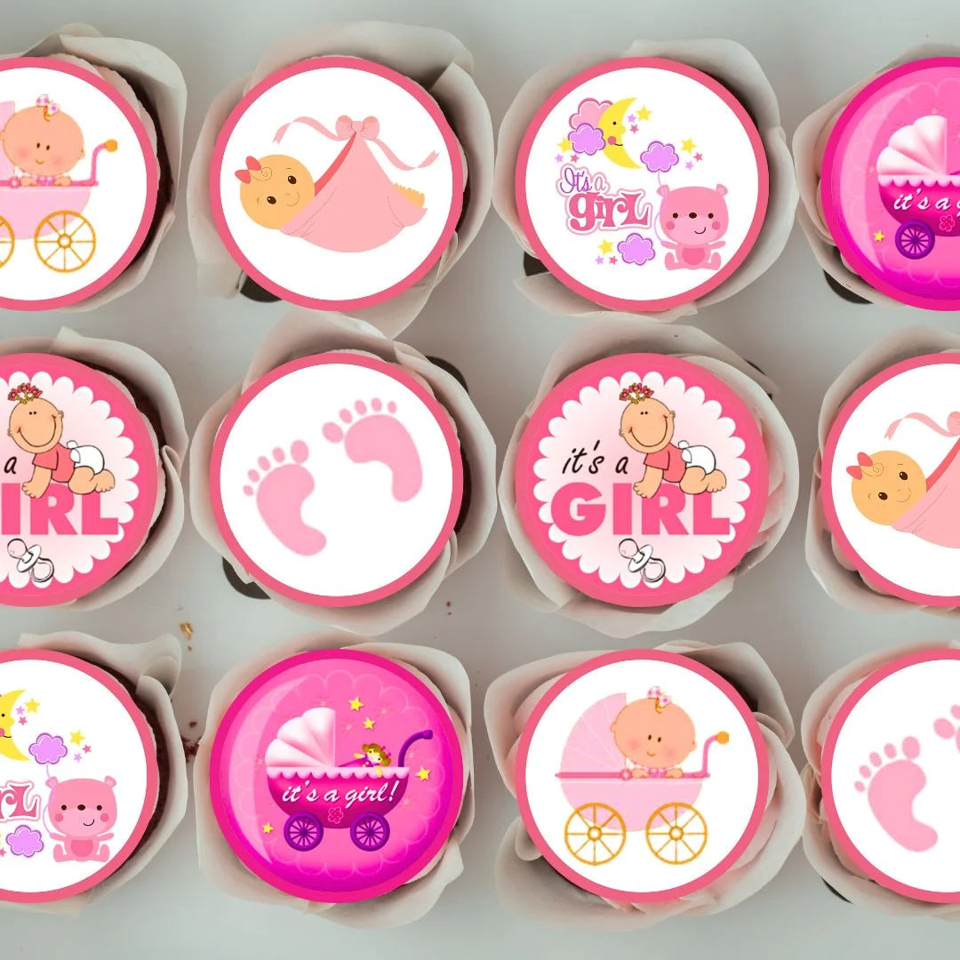 tray of cupcakes with white frosting topped with It's A Girl pink Baby Shower Edible Cupcake Toppers
