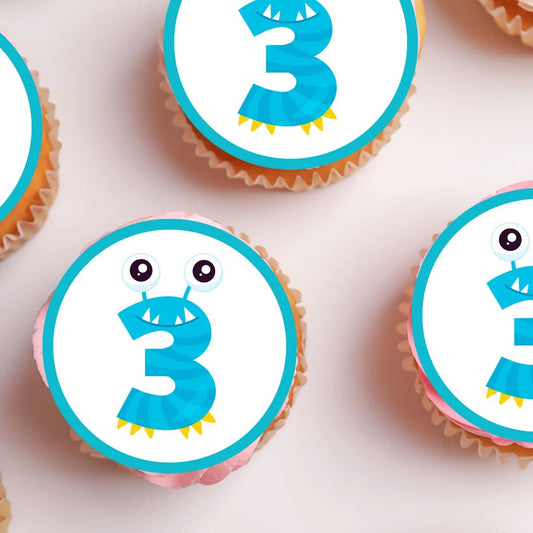 close up of Monster Theme Edible Cupcake Toppers with a blue number 3 on frosted cupcakes
