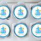 cute cupcake toppers with a blue 1 and illustrated characters on white frosted cupcakes 