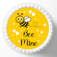 Round cake with a bee and 'Bee Mine' text on a yellow background