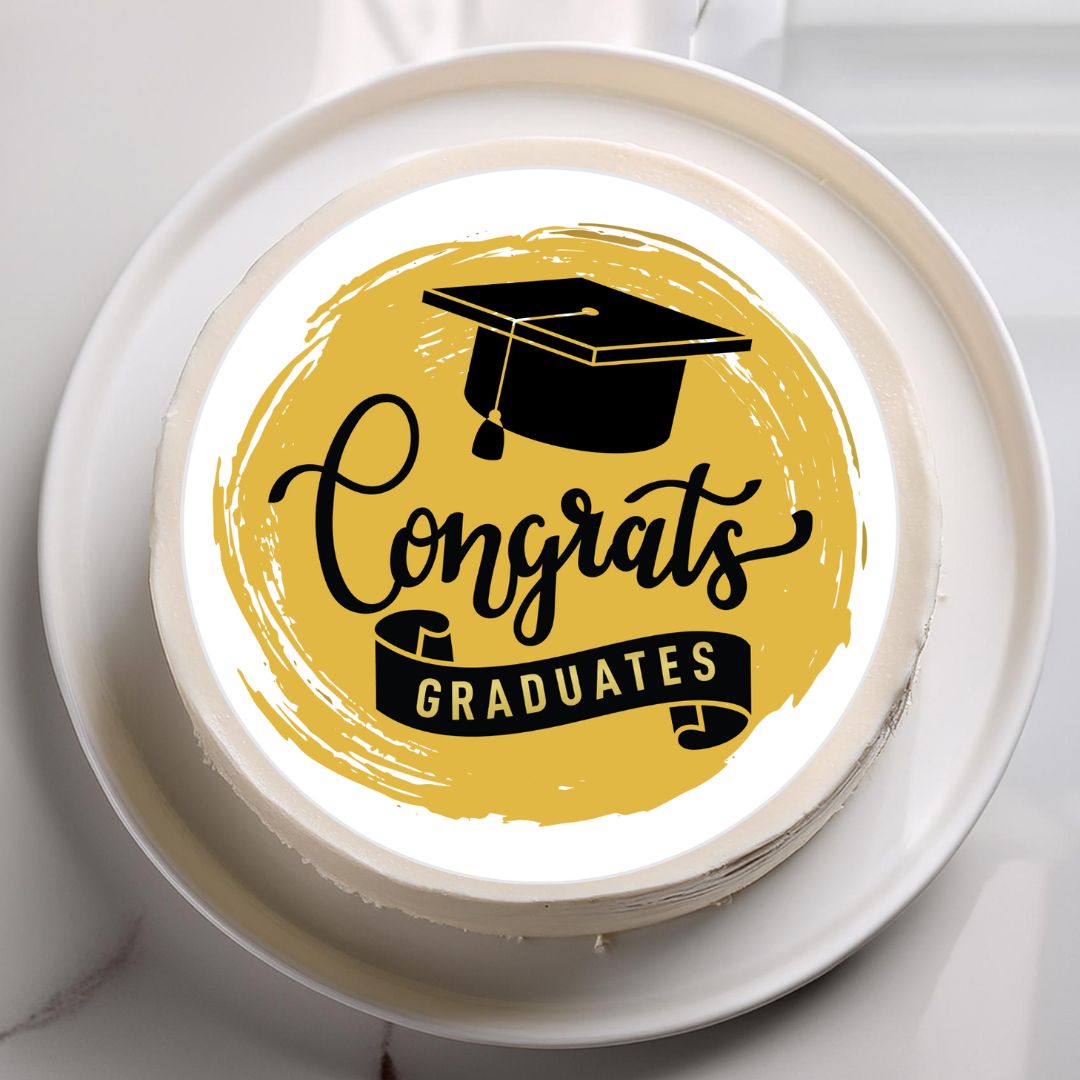 Graduation-themed cake with 'Congrats Graduates' text and cap on a white plate.