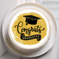 Graduation-themed cake with 'Congrats Graduates' text and cap on a white plate.
