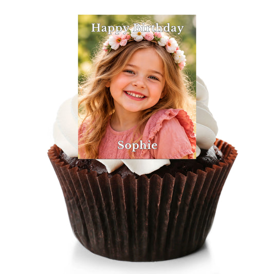 A chocolate cupcake with white frosting and a custom printed photo topper on top. The topper shows a smiling young girl with a flower crown and the text 'Happy Birthday' and 'Sophie'.