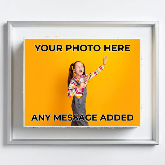 A framed customizable photo print mockup on a white wall. The print features a bright yellow background with placeholder text reading 'YOUR PHOTO HERE' and 'ANY MESSAGE ADDED', with a sample photo of a girl in overalls overlaid in the center.