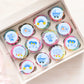 cute blue illustrated baby boy cupcake toppers on rainbow frosted cupcakes