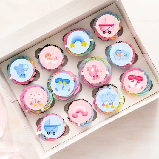 a mix of pink and blue cute illustrated cake toppers on rainbow cupcakes in a tray