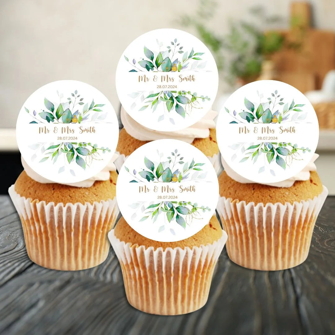 Botanical greenery with gold letting in the middle with a Mr & Mrs name and date of event standing up on cupcakes with white frosting.