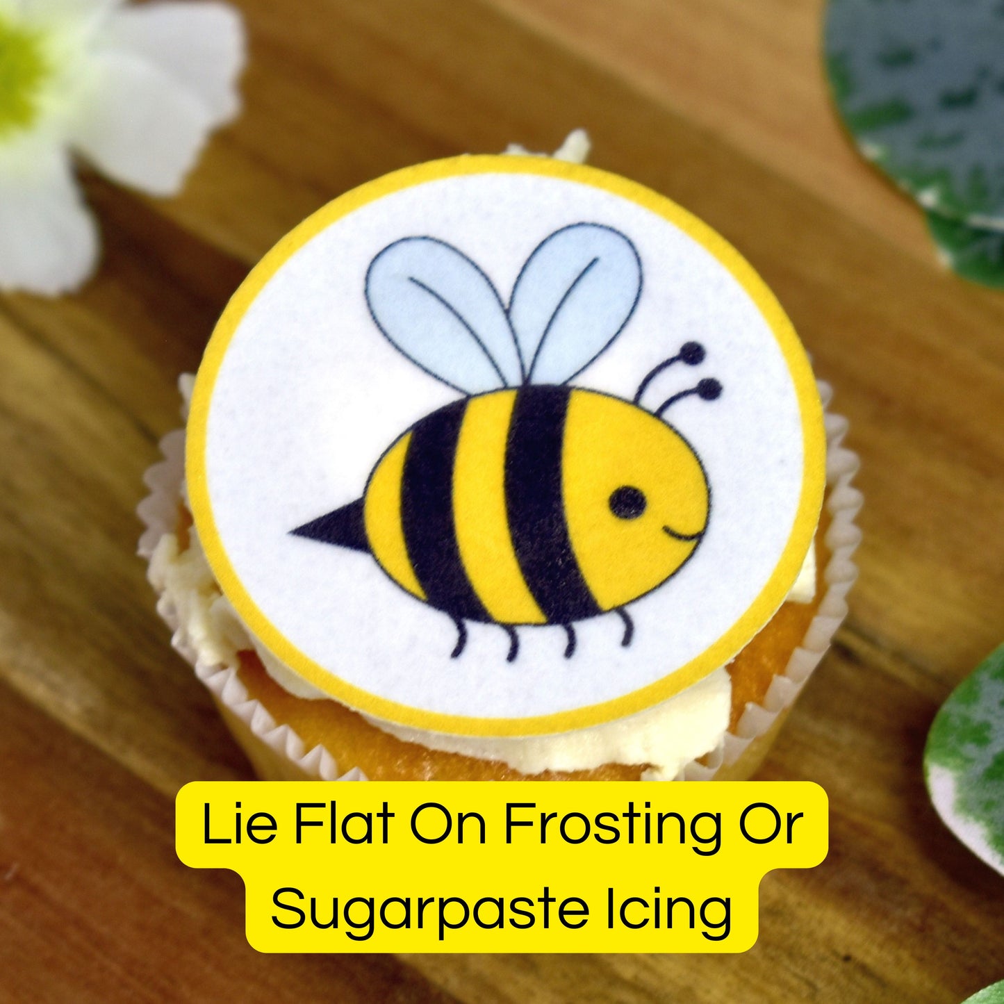 Cupcake with a bee design on top on a wooden surface