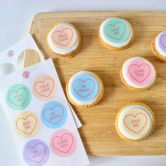 colourful edible cookie decorations placed on white iced biscuits