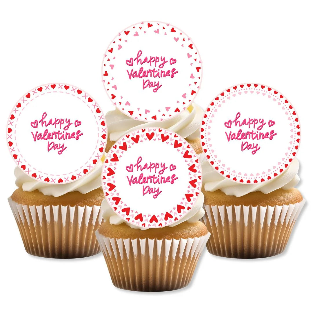 pink and red edible cookie decorations on white frosted cupcakes