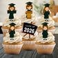 Cupcakes with graduation-themed toppers and 'Class of 2026' sign on a neutral background