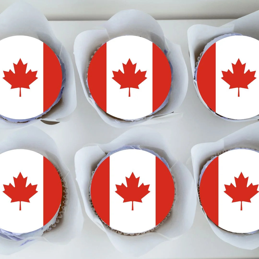 top view of Canadian Flag Round Edible Cupcake Toppers  on chocolate cupcakes with white frosting 