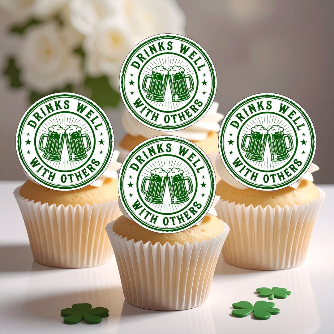 Cupcakes with 'Drinks Well with Others' toppers on a white surface with flowers in the background.