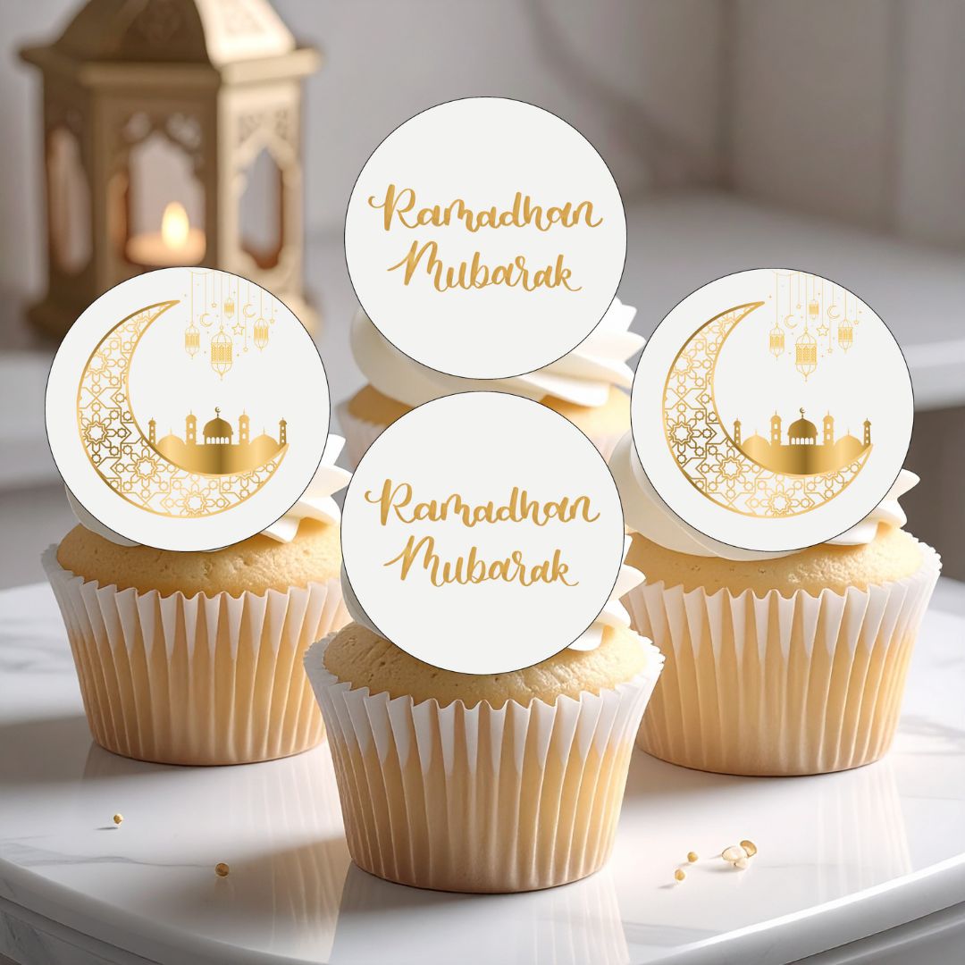 Cupcakes with 'Ramadan Mubarak' toppers on a white surface.