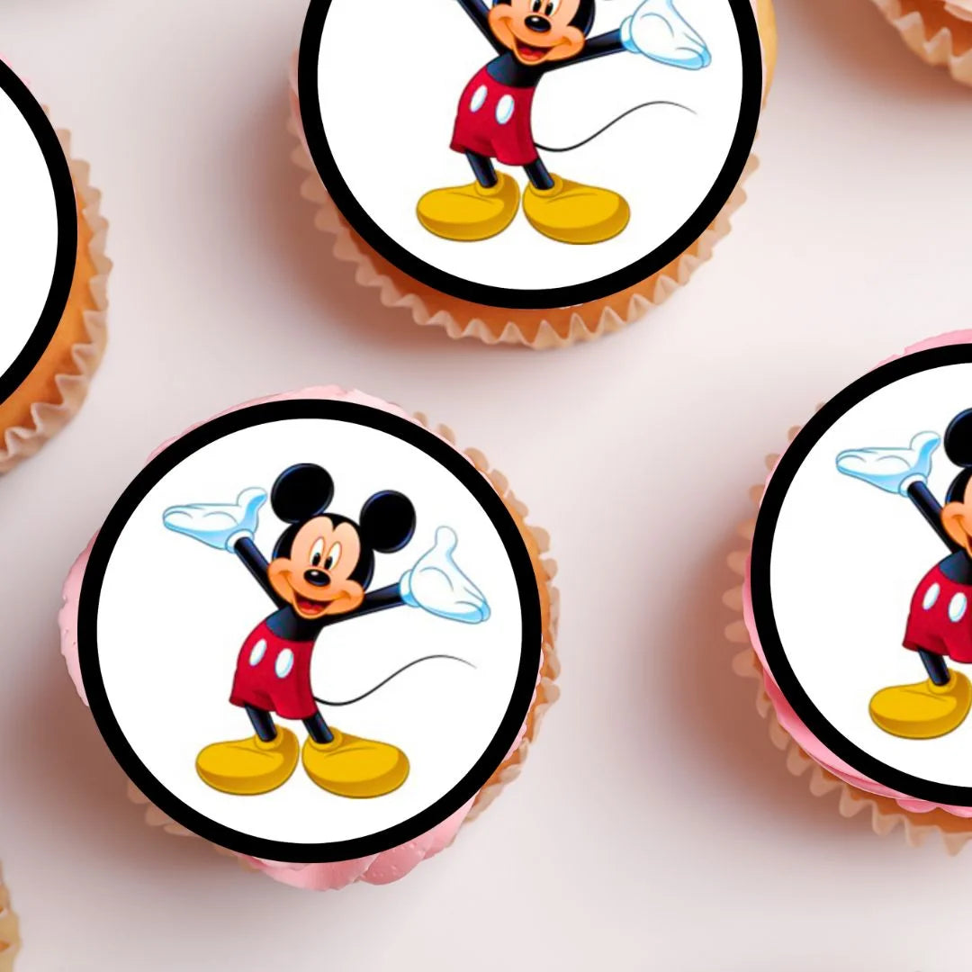 top view of M!ckey Mouse Edible Cupcake Toppers on white frosted cupcakes 