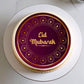 Eid Mubarak cake with decorative purple and gold design on a white plate.