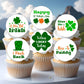 Cupcakes with St. Patrick's Day-themed toppers on a white surface with a mountain background.