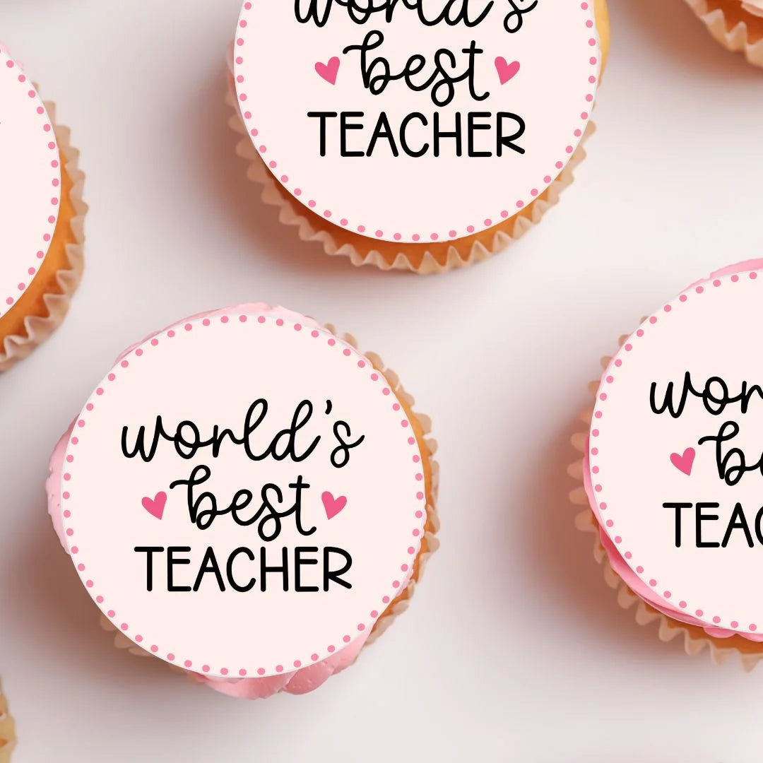 close up of Worlds Best Teacher Cupcake Toppers on pink frosted cupcakes